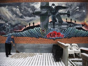 Ronn Anderson, past president of The Royal Canadian Legion, St James Branch No. 4 in Winnipeg, Manitoba and current President of the Manitoba and NW Ontario Command of The Royal Canadian Legions sweeps away snow on a patio in preparation for Remembrance Day at the legion Thursday, November 8, 2018. Legions across Canada are facing funding challenges and volunteer shortages because of aging member demographics.