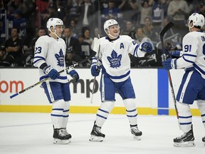 Toronto Maple Leafs center John Tavares, right, celebrates his goal with defenseman Morgan Rielly, center, and defenseman Travis Dermott during the first period of an NHL game against the Los Angeles Kings Tuesday, Nov. 13, 2018, in Los Angeles. (AP Photo/Mark J. Terrill)