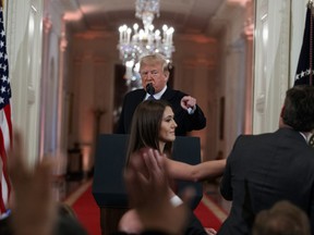 U.S. President Donald Trump watches as a White House aide reaches to take away a microphone from CNN journalist Jim Acosta during a news conference in the East Room of the White House on Nov. 7, 2018. (AP Photo/Evan Vucci, File)