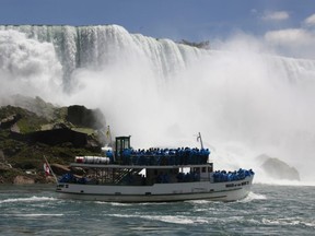 Tourists ride the Maid of the Mist tour boat at the base of the American Falls in Niagara Falls, N.Y.
