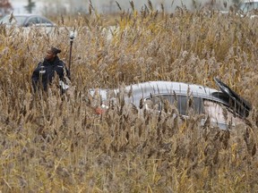 Peel Regional Police major collision officer marks off an area north of Courtneypark Dr.  on Hwy. 410 after a car went into a ditch following a shooting Nov. 13, 2018. (Jack Boland/Toronto Sun)