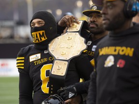 Hamilton Tiger-Cats linebacker Simoni Lawrence (21) puts a wrestling belt over the shoulder of quarterback Jeremiah Masoli (8) during second half CFL Football division semifinal game action against the B.C. Lions in Hamilton, Ont. on Sunday, November 11, 2018. THE CANADIAN PRESS/Peter Power