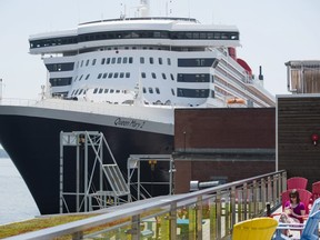 The Queen Mary 2, the luxury liner, sits at dock as people look on in the Halifax Harbour in Halifax on June 13, 2017. THE CANADIAN PRESS/Darren Calabrese