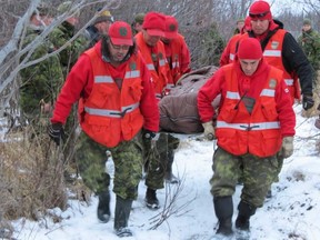 Canadian Rangers carry a patient needing medical attention from the bush in Sachigo Lake, Ontario.