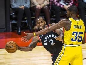 Raptors’ Kawhi Leonard tries to make a pass around the Warriors’ Kevin Durant on Thursday.  Ernest Doroszuk/Toronto Sun
