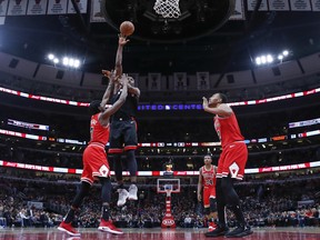 Toronto Raptors forward Serge Ibaka (9) shoots as Chicago Bulls forwards Justin Holiday (7) and Jabari Parker (2) defend during the second half of an NBA basketball game Saturday, Nov. 17, 2018, in Chicago. (AP Photo/Kamil Krzaczynski) ORG XMIT: CXA110