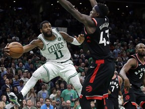Celtics guard Kyrie Irving passes the ball away with Toronto Raptors forward Pascal Siakam providing the defence last night in Boston. Irving scored 43 points as the Raps lost their third game in a row. Elise Amendola/AP
