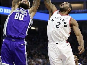 Sacramento Kings center Willie Cauley-Stein, left, and Toronto Raptors forward Kawhi Leonard, right, go for the rebound during the first quarter in Sacramento on Wednesday night. (AP Photo/Rich Pedroncelli)