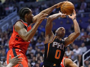 Raptors forward Kawhi Leonard blocks the shot of Phoenix Suns guard Isaiah Canaan during the second half on Friday night. (AP Photo/Matt York)