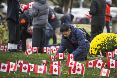 Austin Hua, 15, places a few of the 47,500 Canadian flags on the lawns outside of Sunnybrook Veterans Centre on the grounds at Sunnybrook Health Sciences Centre in Toronto, Ont. on Saturday November 10, 2018. There were 100 flags for each of the 475 veterans that live there. Ernest Doroszuk/Toronto Sun/Postmedia