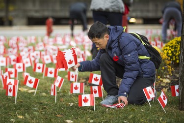 Austin Hua, 15, places a few of the 47,500 Canadian flags on the lawns outside of Sunnybrook Veterans Centre on the grounds at Sunnybrook Health Sciences Centre in Toronto, Ont. on Saturday November 10, 2018. There were 100 flags for each of the 475 veterans that live there. Ernest Doroszuk/Toronto Sun/Postmedia