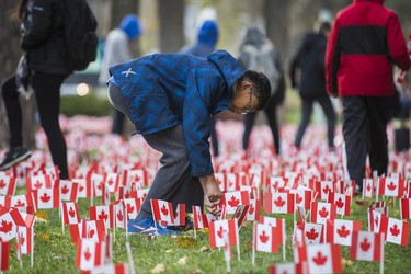 Marco Ho, 12, places a few of the 47,500 Canadian flags on the lawns outside of Sunnybrook Veterans Centre on the grounds at Sunnybrook Health Sciences Centre in Toronto, Ont. on Saturday November 10, 2018. There were 100 flags for each of the 475 veterans that live there. Ernest Doroszuk/Toronto Sun/Postmedia