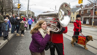 Kim Logan tries out a tuba from Drew Kellas, of the Toronto Second Signals Trumpet Band at the Beaches Santa Claus Parade along Kingston Rd. in Toronto, Ont. on Sunday November 25, 2018. Ernest Doroszuk/Toronto Sun/Postmedia