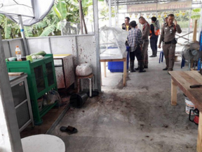 Cops inspect the blood-spattered kitchen of the Bangkok restaurant where vegetarian patrons were served the flesh of a murdered man.