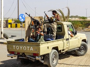 Yemeni pro-government forces cheer as they ride in the back of a pickup truck mounted with a machine gun as they drive in an industrial district in the eastern outskirts of the port city of Hodeida on November 18, 2018. (Getty Images)