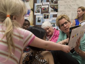 Former premier Kathleen Wynne is pictured reading to a kindergarten class in Guelph in May, 2014. (The Canadian Press)