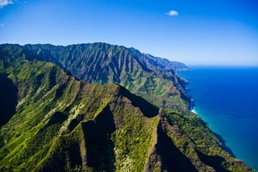 Steep cliffs rise from the Pacific Ocean along the Napali Coast of Kauai, part of the island archipelago of Hawaii. Beaches at the bottom of the cliffs are only accessible by boat. Visitors can get a bird’s eye view from a helicopter. PHOTO COURTESY HAWAII TOURISM AUTHORITY