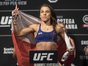 Joanna Jedrzejczyk poses on the scale during the weigh-in ahead of her flyweight bout against Valentina Shevchenko at UFC 231. (THE CANADIAN PRESS)