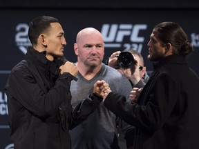 UFC president Dana White (centre) watches as Max Holloway (left) and Brian Ortega stare each other down on Wednesday. (THE CANADIAN PRESS)