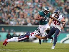 Running back Josh Adams #33 of the Philadelphia Eagles is tackled by cornerback Aaron Colvin #22 and defensive end J.J. Watt #99 of the Houston Texans during the fourth quarter at Lincoln Financial Field on December 23, 2018 in Philadelphia, Pennsylvania.  The Philadelphia Eagles won 32-30.