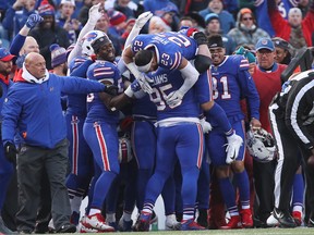 Kyle Williams #95 of the Buffalo Bills is congratulated by Micah Hyde #23 and teammates after catching a pass and running with the ball in the fourth quarter during NFL game action against the Miami Dolphins at New Era Field on Dec. 30, 2018 in Buffalo, N.Y. Williams was playing in the final game of his career. (Tom Szczerbowski/Getty Images)