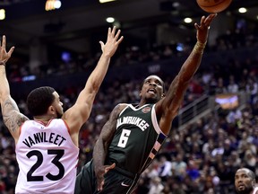 Raptors guard Fred VanVleet tries to defend against Milwaukee Bucks guard Eric Bledsoe during Sunday's game. (THE CANADIAN PRESS)