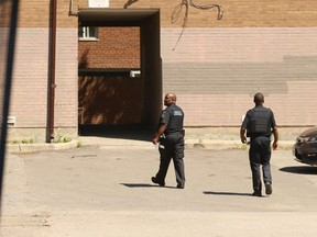 Special constables walk though a TCHC building  Shoreham Crt. in July after a man was killed there. (Jack Boland, Toronto Sun)