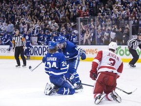 Toronto Maple Leafs Morgan Rielly (centre) congratulates teammate Kasperi Kapanen after he scored the game-winning goal in overtime against the Detroit Red Wings on Sunday. (THE CANADIAN PRESS)