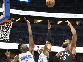 Toronto Raptors center Greg Monroe shoots over the Orlando Magic's Mo Bamba (left) and Terrence Ross during Friday's game. (AP PHOTO)