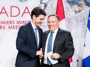 Prime minister of Canada Justin Trudeau (L) with premier of Quebec François Legault (R) shake hands during a meeting with Canadian prime ministers in Montreal, on December 7, 2018 at the Marriott Chateau Champlain.