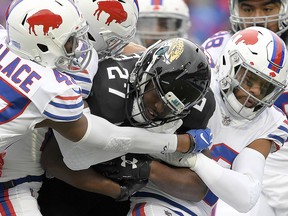 In this Nov. 25, 2018, file photo, Jacksonville Jaguars running back Leonard Fournette (27) is tackled by Buffalo Bills defenders in Orchard Park, N.Y. (AP Photo/Adrian Kraus, File)