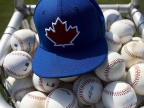 A Toronto Blue Jays practice hat sits on baseballs during baseball spring training in Dunedin, Fla., on February 21, 2013. (THE CANADIAN PRESS/Nathan Denette)