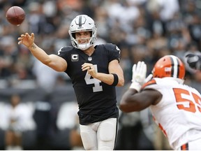 FILE - In this Sunday, Sept. 30, 2018, file photo, Oakland Raiders quarterback Derek Carr (4) passes against Cleveland Browns linebacker Genard Avery (55) during overtime of an NFL football game in Oakland, Calif.