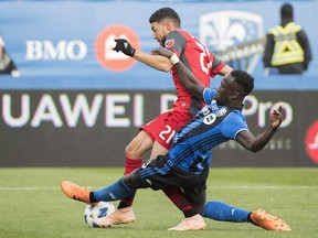 Montreal Impact defender Bacary Sagna Sagna, right, challenges Toronto FC's Jonathan Osorio during second half MLS soccer action in Montreal, Sunday, Oct. 21, 2018. (THE CANADIAN PRESS/Graham Hughes)