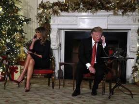 U.S. President Donald Trump and first lady Melania Trump each speak on the phone sharing updates to track Santa's movements from the North American Aerospace Defense Command (NORAD) Santa Tracker on Christmas Eve, Monday, Dec. 24, 2018.