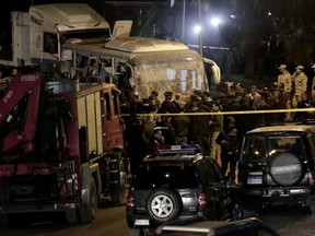 Security forces stand near a tourist bus after a roadside bomb in an area near the Giza Pyramids in Cairo, Egypt.