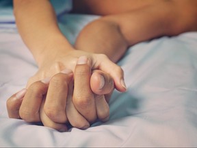 man and woman hands having sex on a bed.