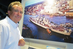 Capt. Terry Bragg (ret.), executive director of Battleship North Carolina, with photo of the 1940 ‘state class’ behemoth’ beingeased along Cape Fear River to its Wilmington, N.C. memorial site in1962. (Ian S. Robertson)