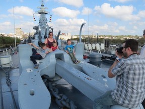 A visitor photographs his children and wife on giant anchor on the bow of USS North Carolina, a 1940 U.S. Navy battleship, at Wilmington, N.C. (Ian S. Robertson)