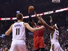 Raptors third-string centre Greg Monroe (15) shoots over Indiana Pacers forward Domantas Sabonis (11) and centre on Wednesday night at Scotiabank Arena. (Frank Gunn/The Associated Press)