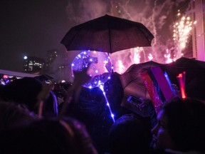 People watch the fireworks during New Year's Eve celebrations held at Nathan Phillips Square in Toronto just after midnight, Tuesday, Jan. 1, 2019.