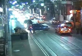 In an image released by Toronto Police, a vehicle, believed to be a blue Mazda and carrying the gunman, leaves the scene of a fatal double shooting on King St. W. on Wednesday, Dec. 19, 2018.