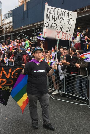 A marcher holding a sign critical of the police during the 2018 Toronto Pride Parade in Toronto, Ont. on Sunday June 24, 2018. (Sue-Ann Levy /Toronto Sun)
