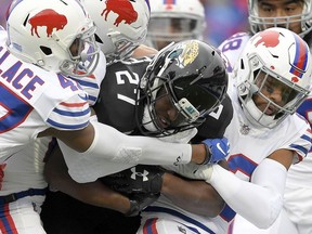 In this Nov. 25, 2018, file photo, Jacksonville Jaguars running back Leonard Fournette (27) is tackled by Buffalo Bills defenders during the first half of an NFL football game, in Orchard Park, N.Y.