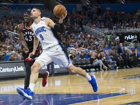 Orlando Magic centre Nikola Vucevic heads past Toronto Raptors forward Pascal Siakam in Orlando Friday night. Siakam was held to just four points against Orlando, shooting a career-worst 1-for-8 from the field. (AP)