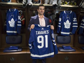 John Tavares holds up a jersey after signing with the Maple Leafs in July. (Chris Young/The Canadian Press)