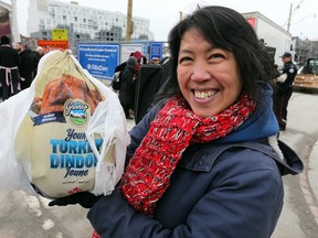 Corinne Wong, who will be donating her turkey to her own charity as the tradition continues for the annual Honest Ed's turkey giveaway, handing out thousands of turkeys at the former site of Honest Ed's at Bloor and Bathurst on Sunday. (Dave Abel/Toronto Sun)