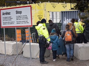 A family, claiming to be from Colombia, is arrested by RCMP officers as they cross the border into Canada from the United States as asylum seekers on April 18, 2018 near Champlain, N.Y.