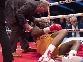 Ring doctor Marc Gagne, left, checks on Adonis Stevenson, of Montreal, after he was knocked out by Oleksandr Gvozdyk of Ukraine in their Light Heavyweight WBC championship fight, Saturday, December 1, 2018 in Quebec City.