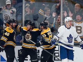 Boston Bruins' David Krejci celebrates his goal with teammates Brad Marchandand David Pastrnak as Toronto Maple Leafs' Nikita Zaitsev  skates away during the third period of an NHL game in Boston, Saturday, Dec. 8, 2018.